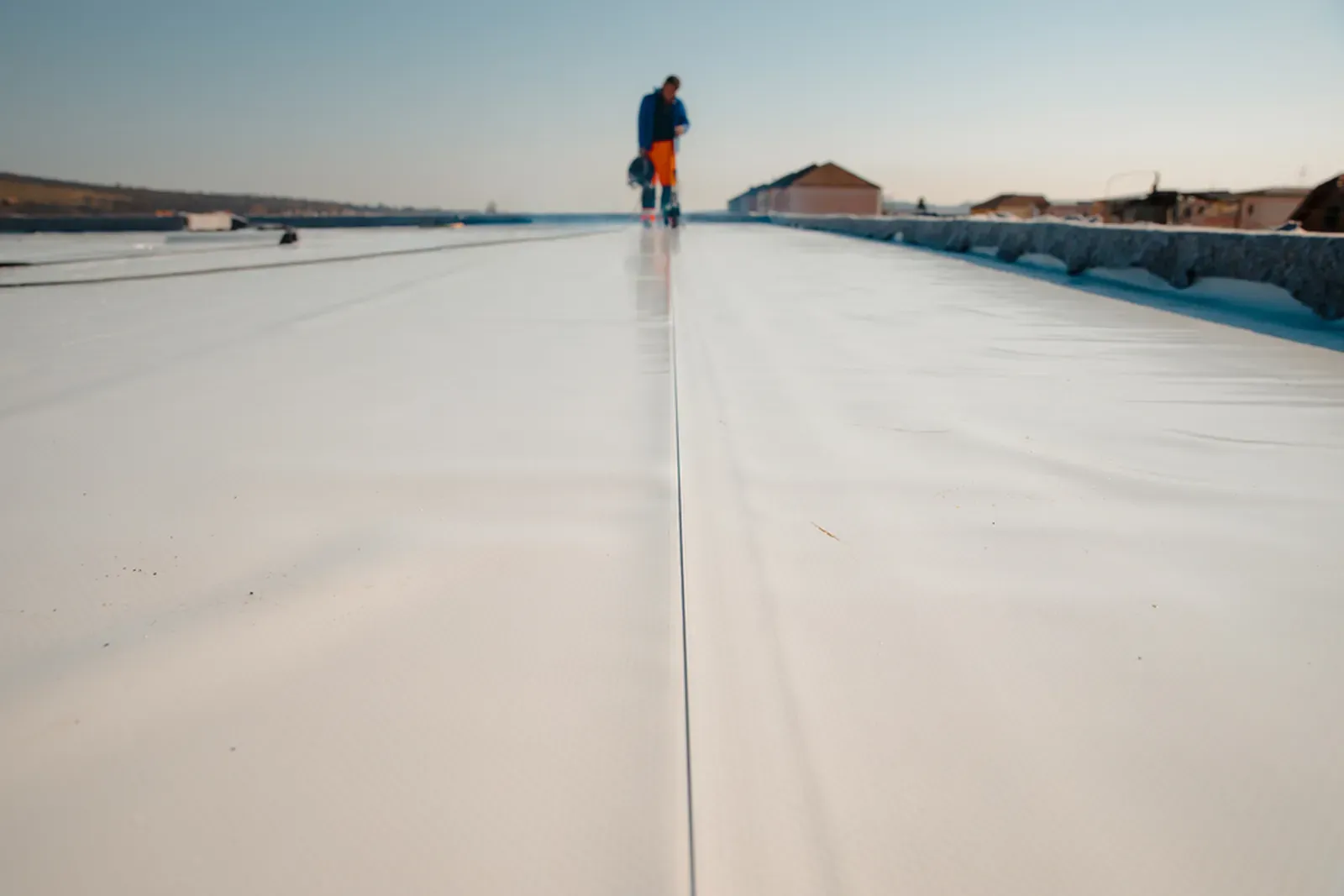 A rooftop being coated with a protective sealant. | New Jersey Gutter