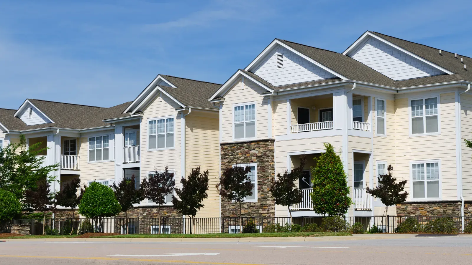 A new asphalt shingle roof and vinyl siding on a multi-family building. | New Jersey Gutter