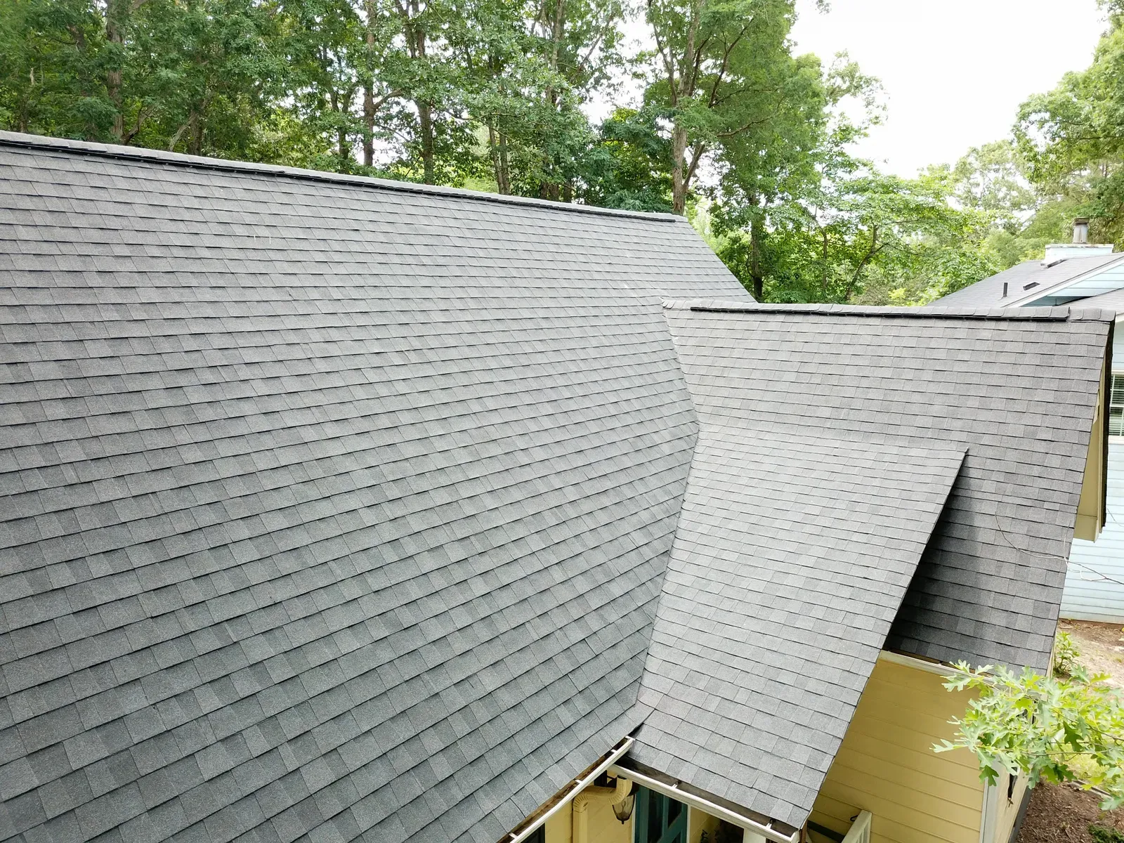 A new asphalt roof being installed on a residential building. | New Jersey Gutter