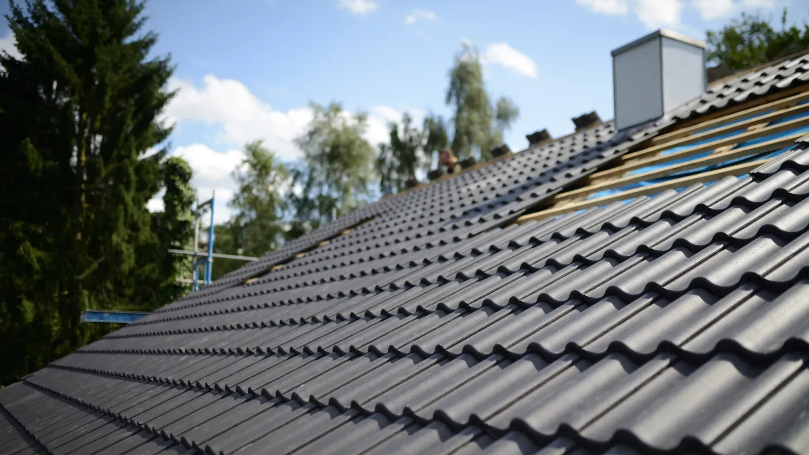 A residential roof with tile under repair. | New Jersey Gutter